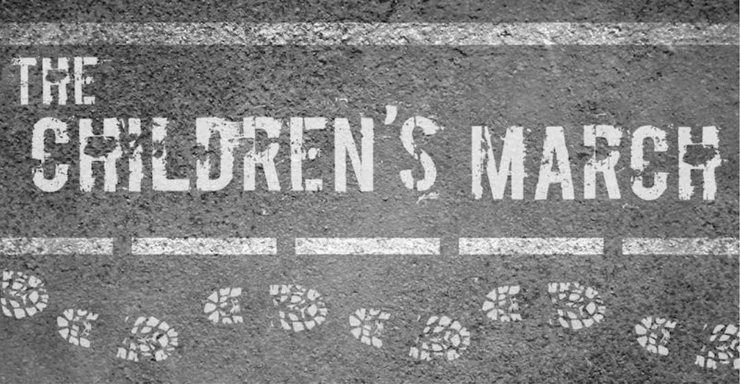 The words The Children's March painted on pavement, with footprints